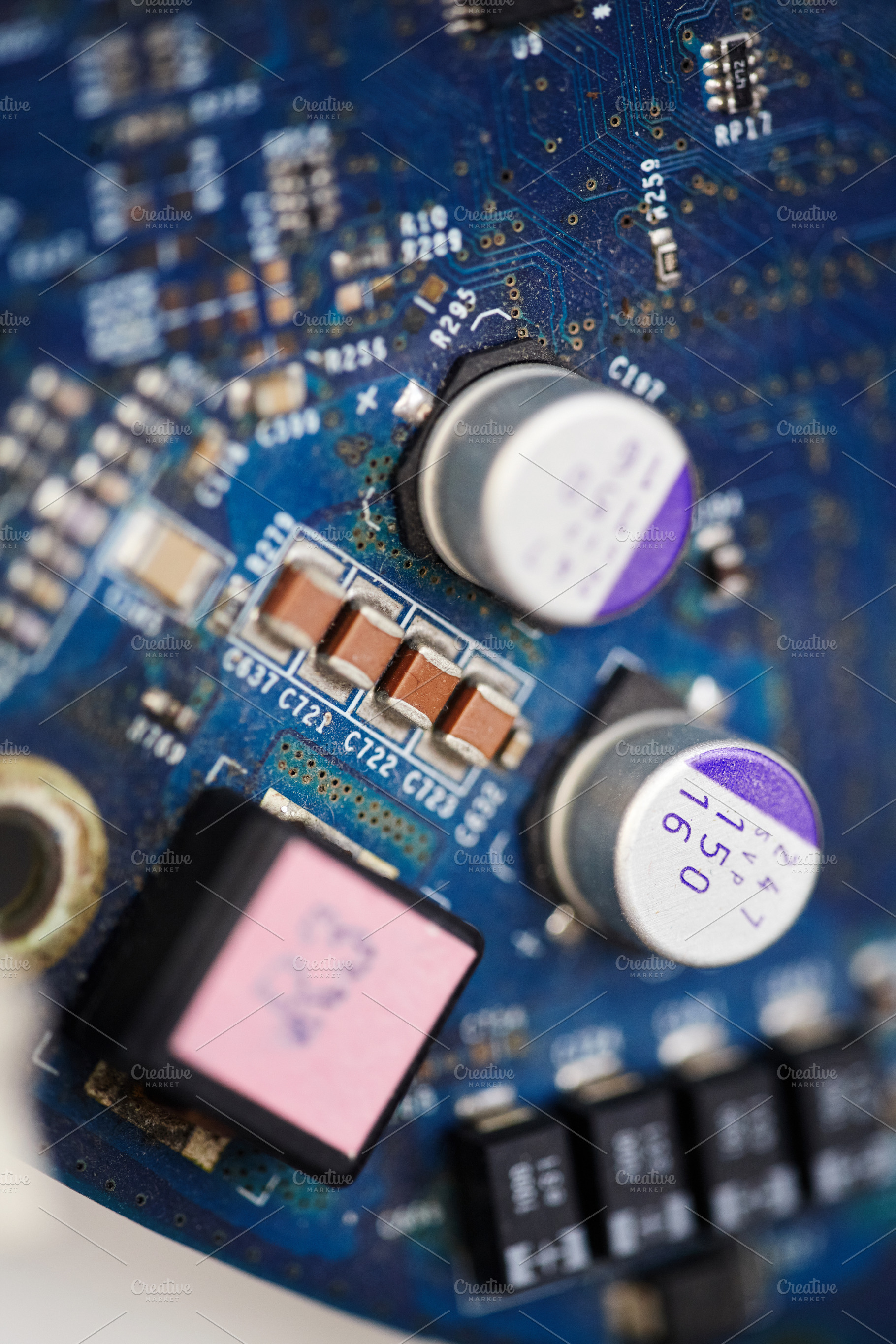 Vertical macro shot of blue circuit board with capacitors and microchips., a Technology Photo by Rohan Photography