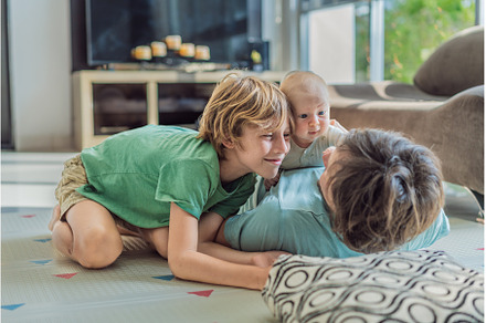 Father, son, and newborn baby lying
