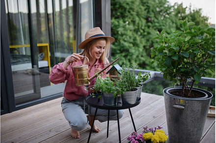 Young woman taking care of her herbs, a Person Photo by HalfPoint