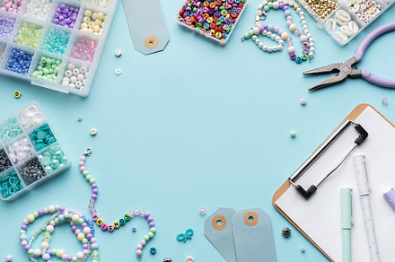 Colorful beads, pliers, clipboard and price tags arranged on blu, an Arts & Entertainment Photo by Olena Rudo