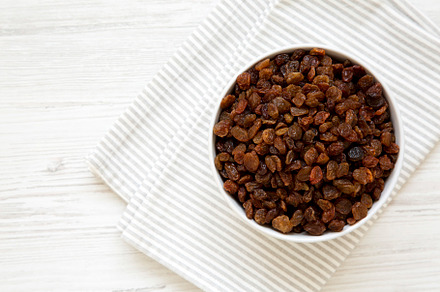 Dried Brown Raisins in a Gray Bowl, top view. Flat lay, overhead, a Food & Drink Photo by LiudmylaChuhunova