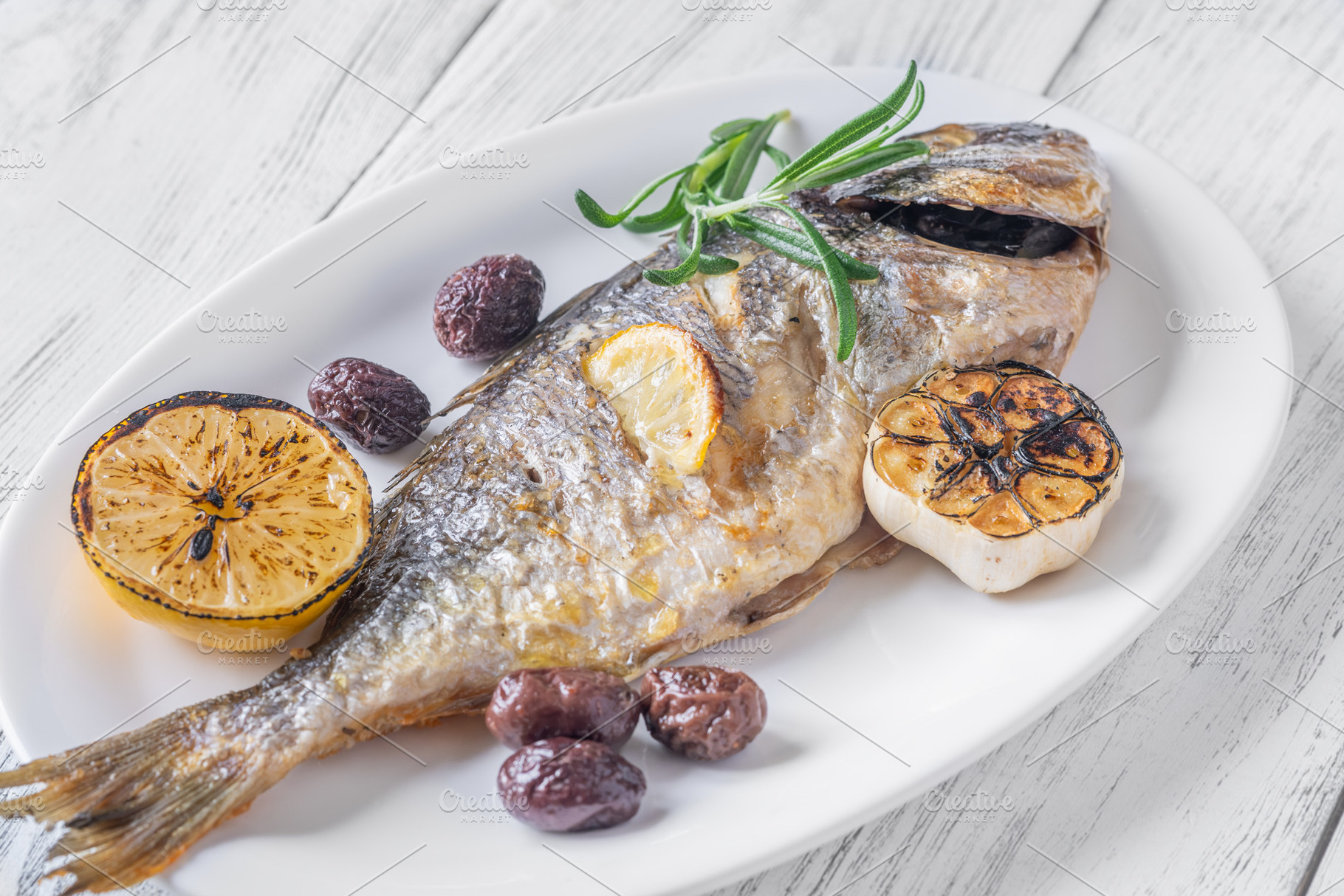 Whole roasted sea bream with lemon rosemary olives and carameliz, a Food & Drink Photo by Alexander Prokopenko