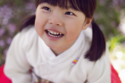 Korean girl child in a national costume walks in a garden with cherry blossoms, a Person Photo by SaulichPhoto