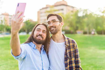 A happy gay couple taking a selfie in the park, a Person Photo by Iván Moreno STOCK PHOTO
