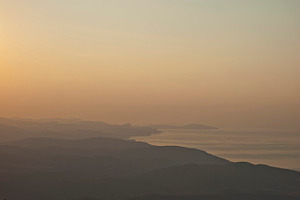 Orange sunset featuring sunset, mountain, and beach