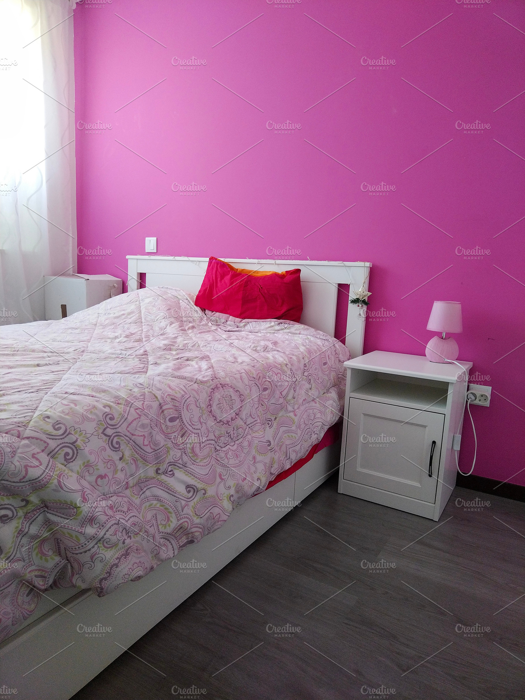 Cozy bedroom with pink wall and floral bed, an Architecture Photo by DanFLCreativo