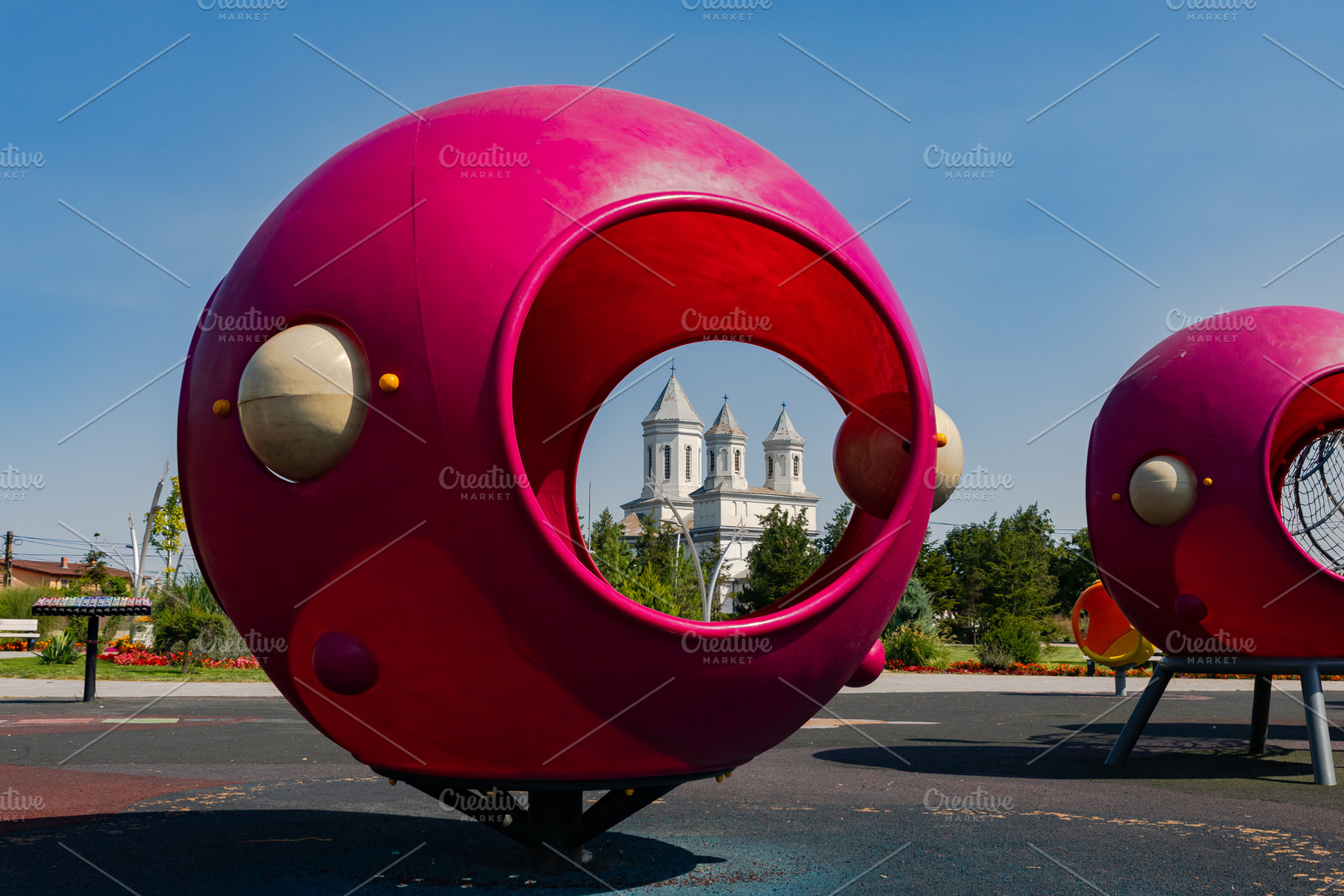 Bright pink playground structures with circular openings, set in a park, with a, a Sports & Recreation Photo by Ales Munt