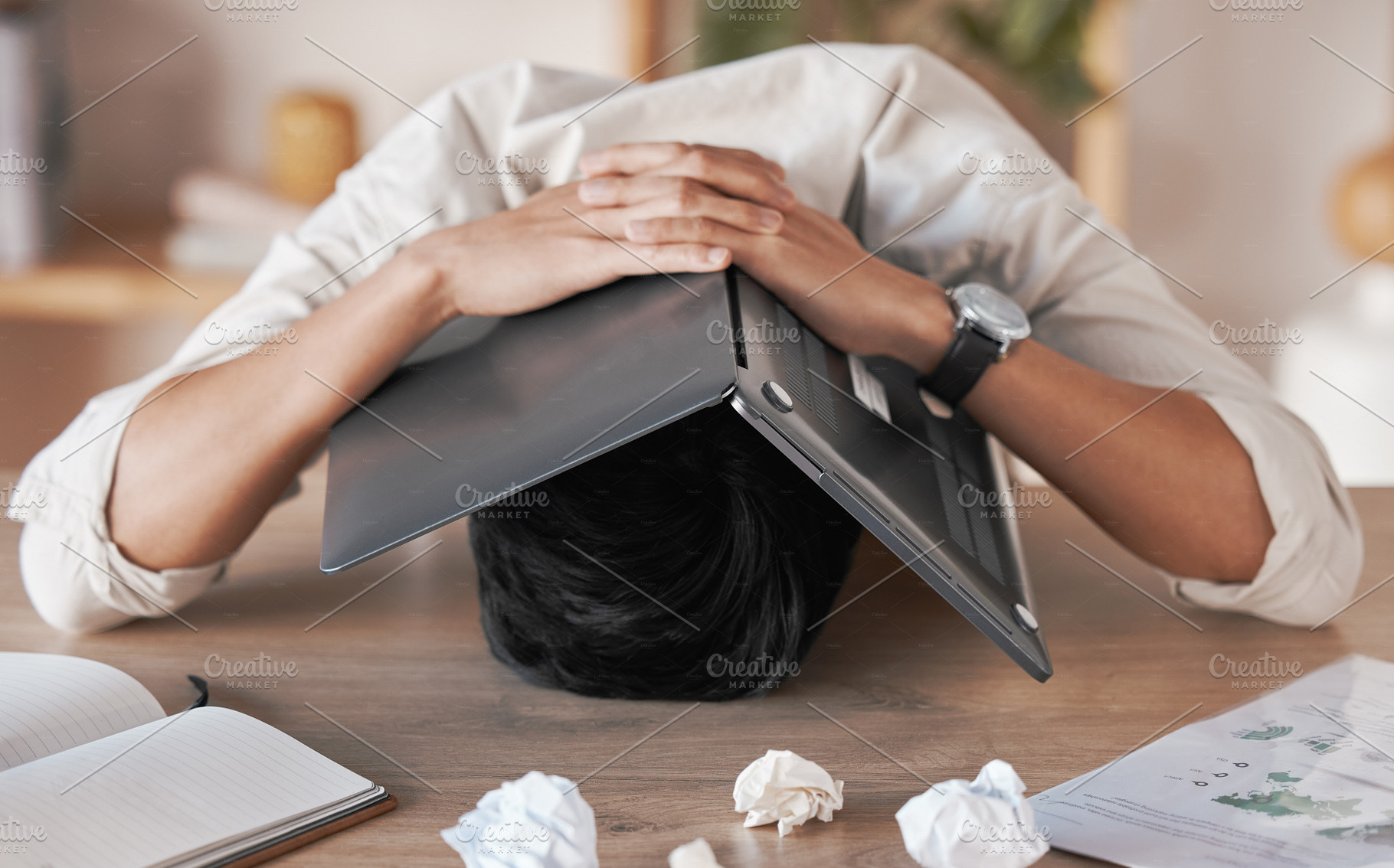 Stress, frustrated and burnout for man with laptop to cover face, head or skull overwhelmed with paperwork. Marketing business man with crumble paper and frustration from work load, chaos or problem, a Photo by Peopleimages.com
