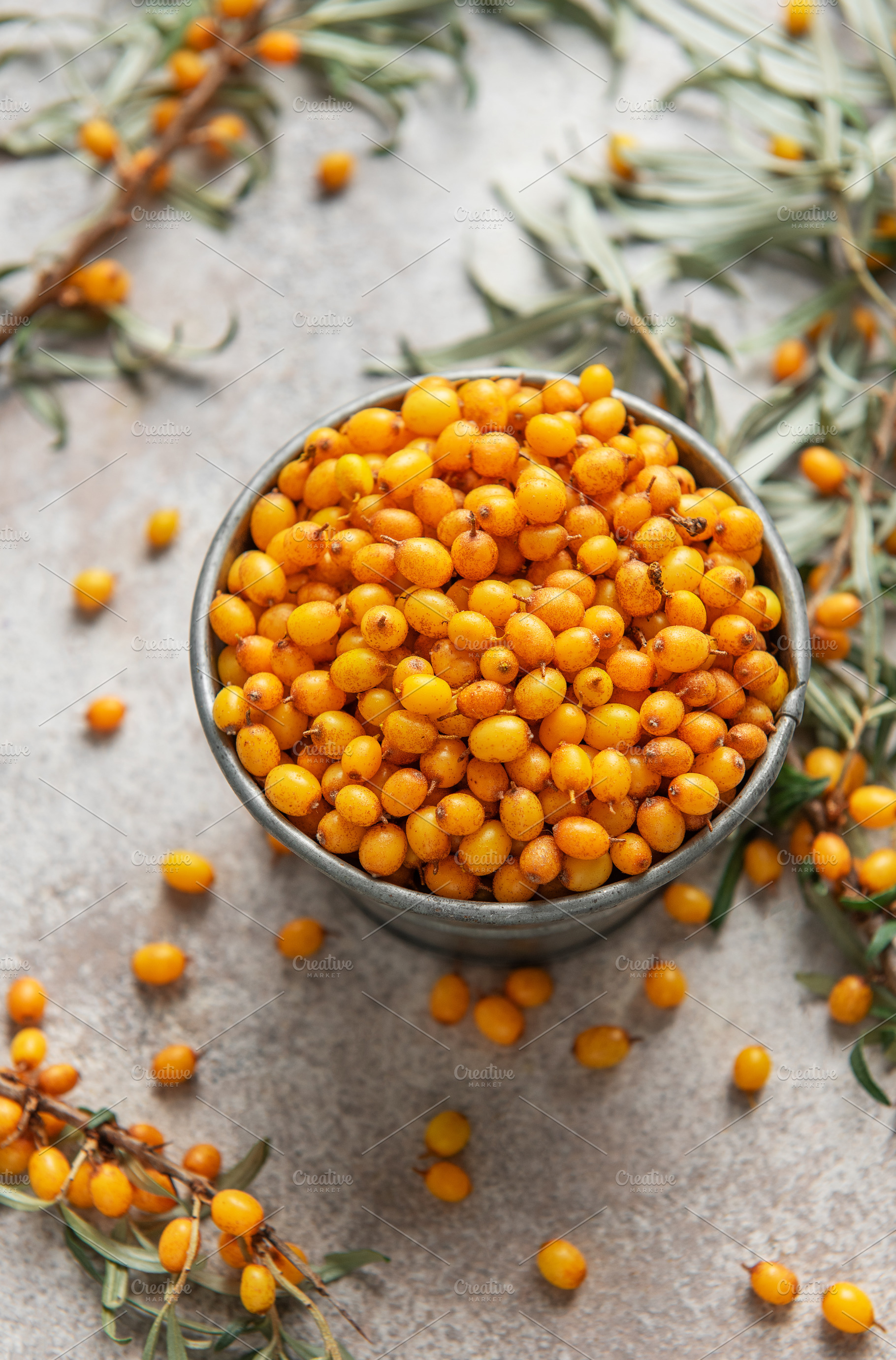 Fresh sea buckthorn berries overflowing a small metal bucket, a Food & Drink Photo by Olena Rudo