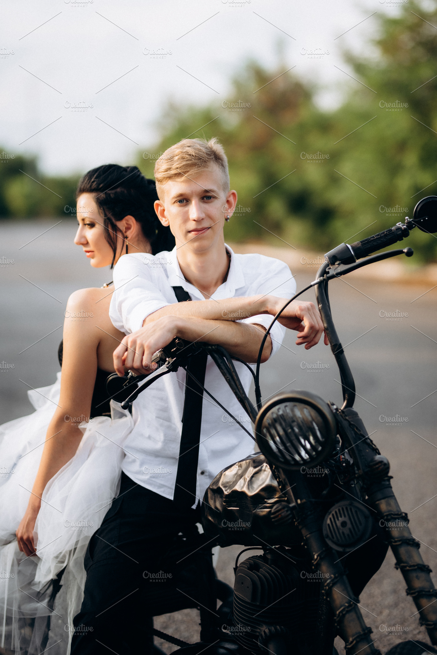 A couple of newlywed freaks on a black custom bike, a Person Photo by Weddings, People, Travel