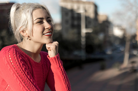 Slim young woman with blonde hair touching face and looking at camera while lea, a Person Photo by 2Design