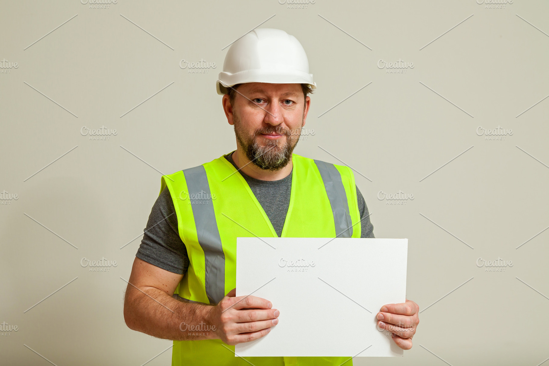 Construction worker in safety gear holding blank sign, a Person Photo by Photostock