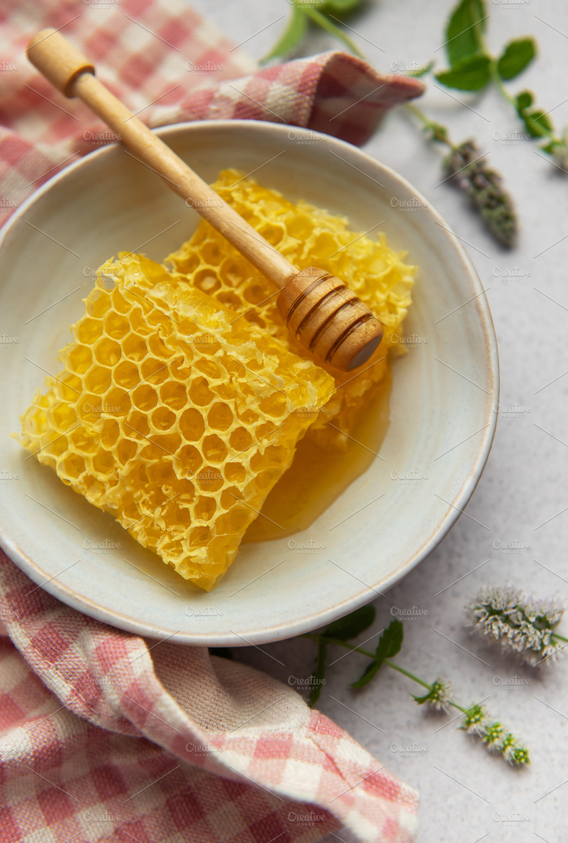 Honeycomb resting in bowl with honey dipper and fresh mint, a Food & Drink Photo by Olena Rudo