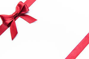 Red ribbon bow on a white background creating border, a Holiday Photo by Olena Rudo