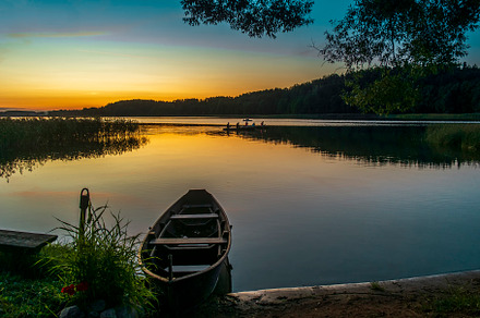Sunset and old wooden fishing boat featuring sky, dusk, and summer, a Nature Photo by verkelis