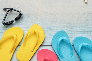 Colorful flip flops and sunglasses resting on beach boardwalk, e, a Holiday Photo by Olena Rudo