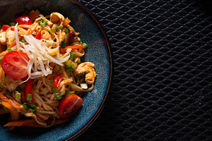 Noodles with Chicken and Vegetables on Dark Plate with Copy Spac, a Photo by MDBildes