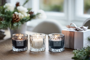 Scented candles glowing on wooden table with elegant gift box, c, a Photo by Studio ANNA