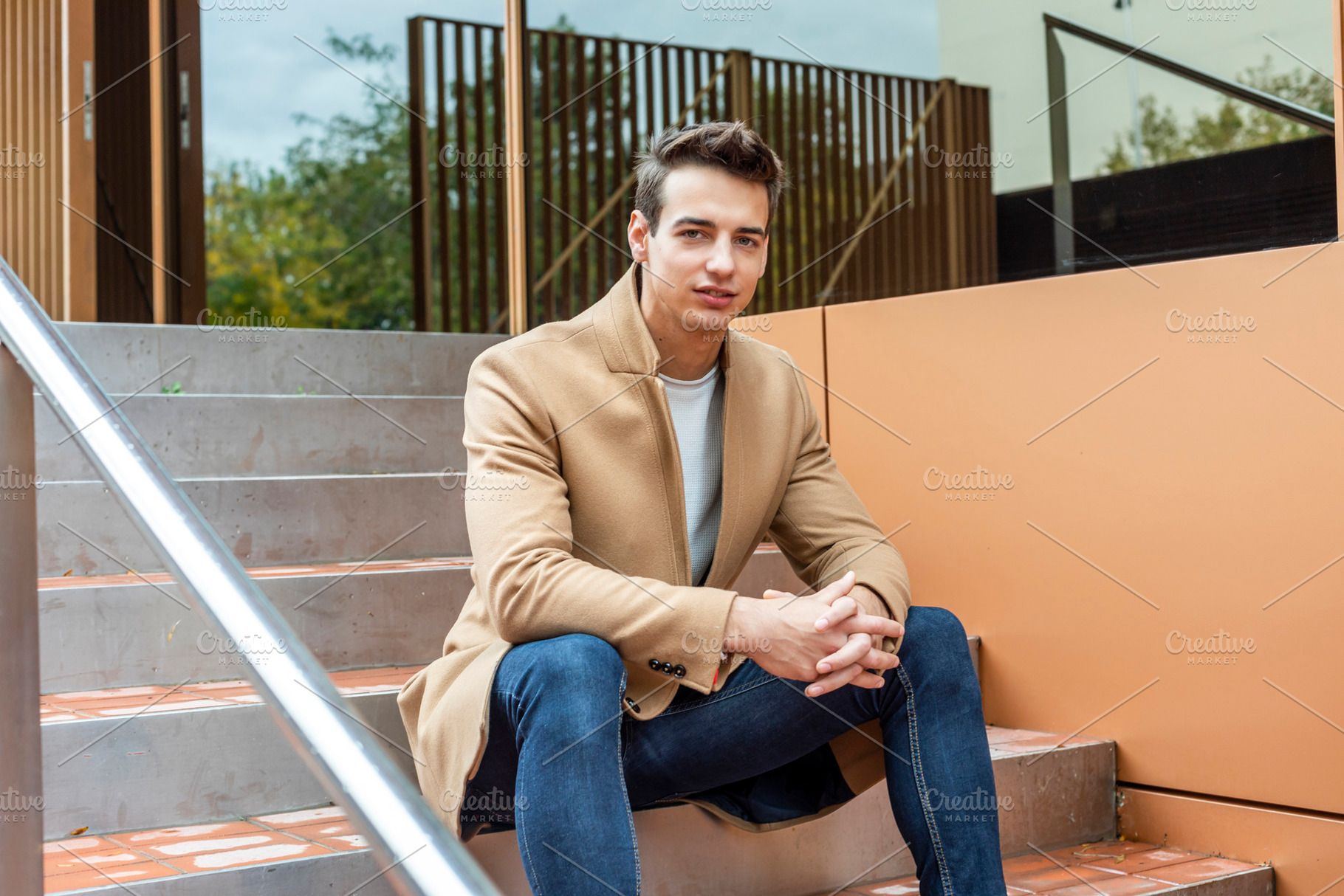 Confident young man sitting on modern outdoor steps, a Person Photo by RF Images