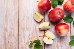 Red apples and slices on light wood background, a Food & Drink Photo by Olena Rudo