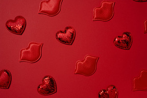 Red decorative hearts and lips randomly placed on a bright red b, a Holiday Photo by ndanko