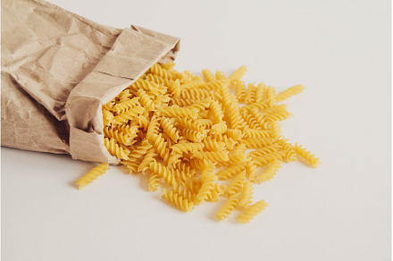 Spiral pasta in a paper bag on a, a Food & Drink Photo by olhovyi_photographer