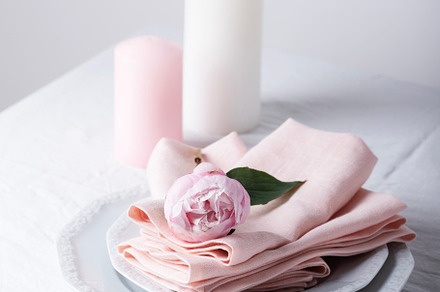 White linen, pink peony and candles