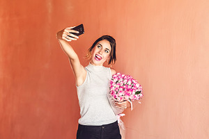 devshuk makes a photo on the phone for memory with a large bouquet of roses. large bouquet. celebration. is crooked on the camera. beautiful and happy