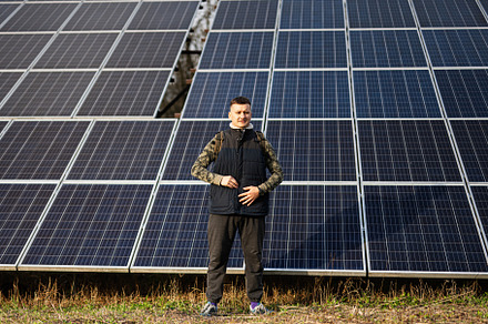 Man on the background of solar panels.  Eco energy., a Technology Photo by AS photostudio