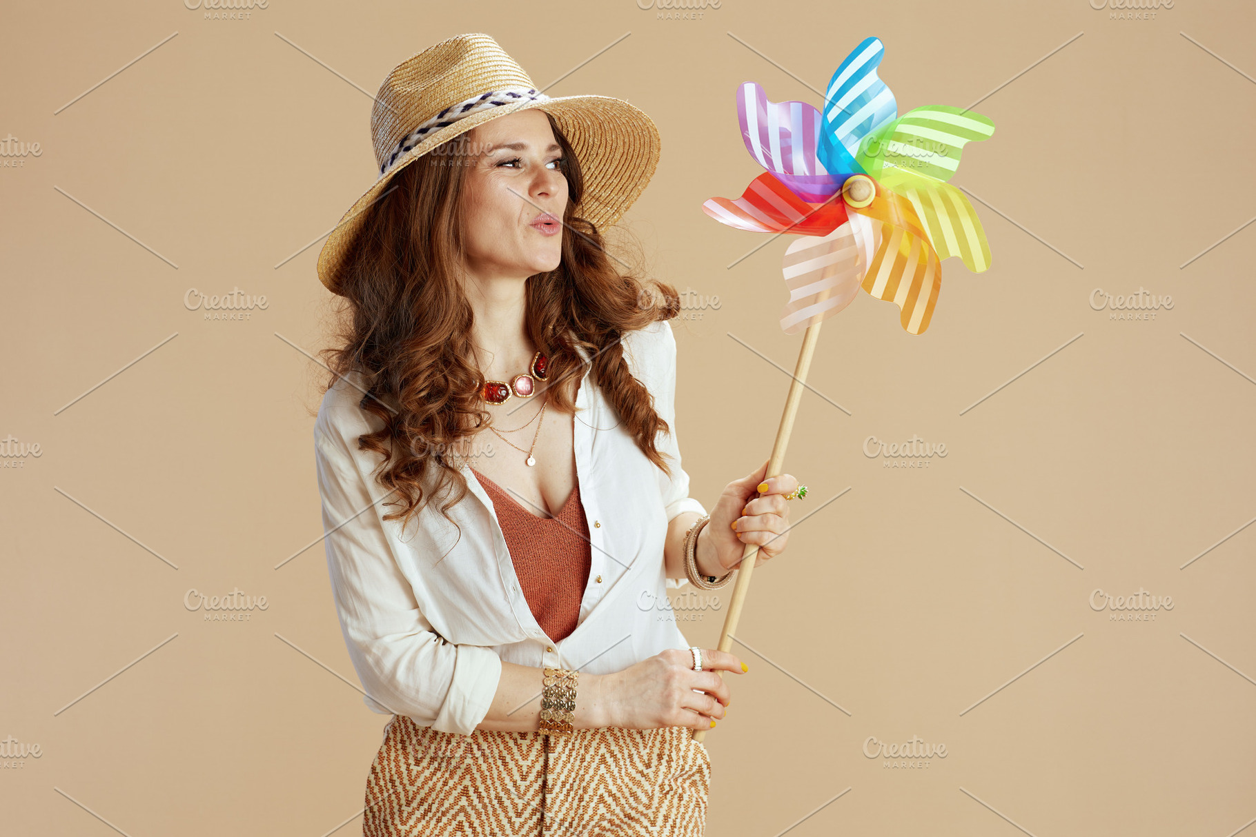 smiling trendy housewife in blouse and shorts against beige, a Person Photo by Alliance Images