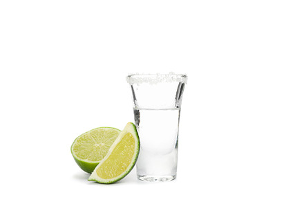 Tequila shot with lime and salt isolated on white background, a Food & Drink Photo by AtlasStudio
