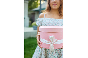 Young girl holds gift box in garden