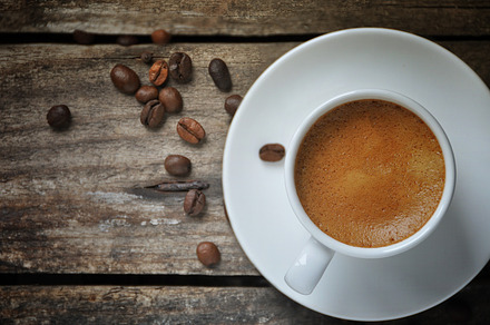 Espresso coffee cup containing coffee, coffee beans, and expresso