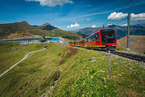 Red tourist train and mountain lake, a Transportation Photo by Alpine Dreams