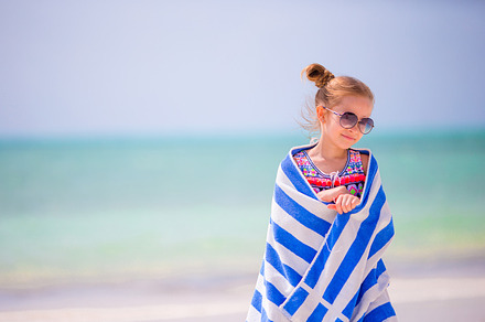 Adorable happy smiling little girl with towel on beach vacation containing, a Person Photo by travnikovstudio