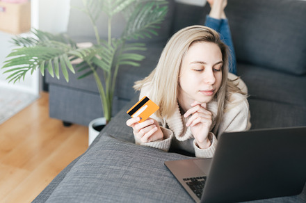 Young woman holding credit card and using laptop computer., a Business Photo by Olena Rudo