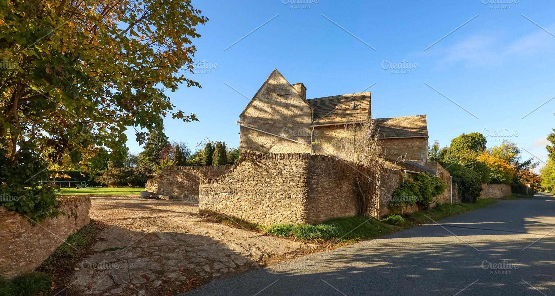 English Cotswold stone house with traditional stone walls border, a Photo by Studio ANNA