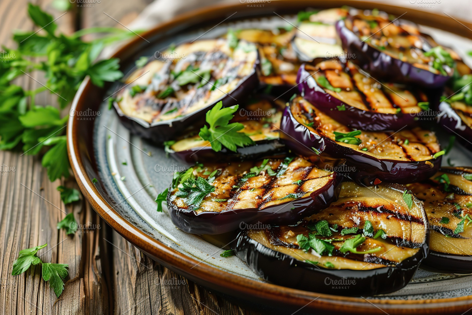 Grilled eggplants in plate on wooden table, a Food & Drink Photo by AlyaAnd
