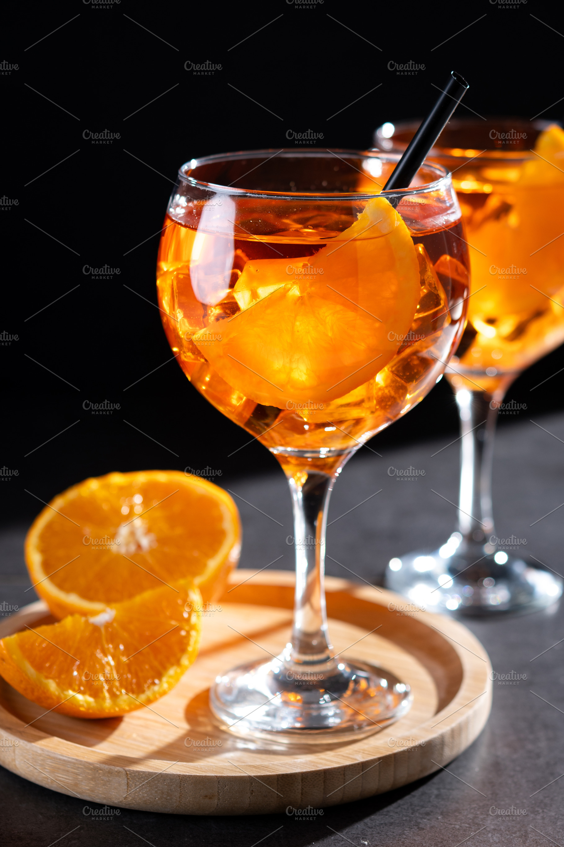 Refreshing Aperol Spritz cocktails with orange slices and ice in elegant glasse, a Food & Drink Photo by etorres69