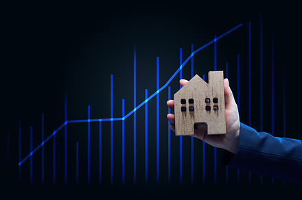 Hand holds a wooden model of a house on a dark background. Real, a Business Photo by ndanko