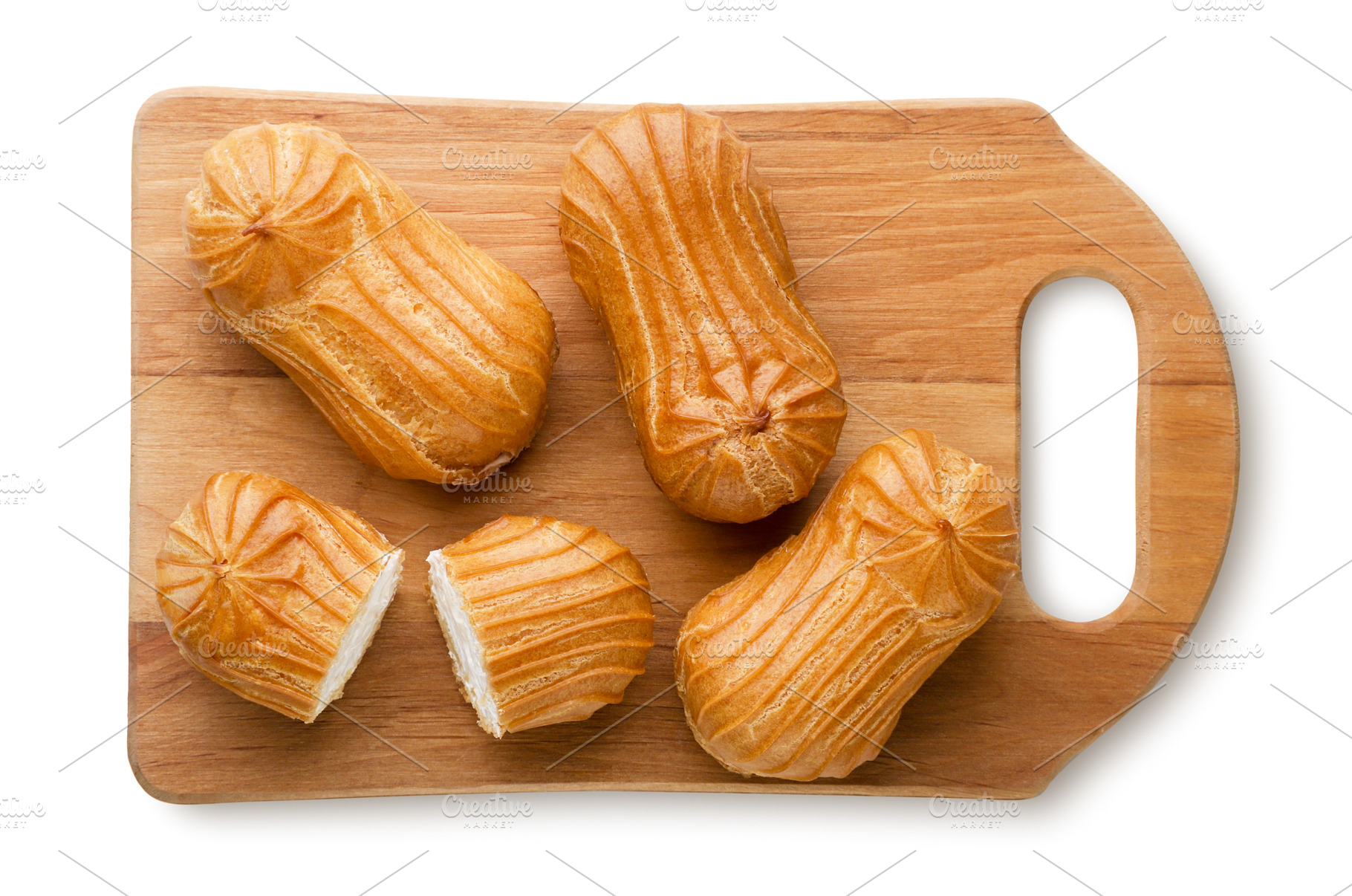 Eclairs and halves on a wooden board, a Food & Drink Photo by innakreativ