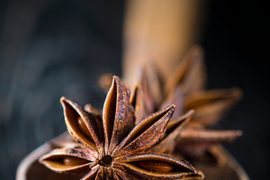 Star anise seeds in a wooden spoon featuring star anise, anise, and seed
