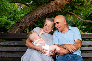 Elderly couple joyfully holding baby, a Person Photo by Elena Vagengeim