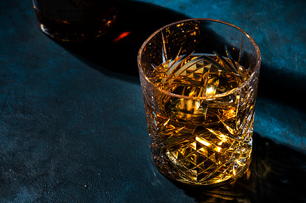 Glass of golden scotch whiskey on dark bar table background, sel, a Food & Drink Photo by 5PH