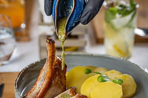 Chef pouring sauce on grilled pork ribs, a Photo by Grafvision photography