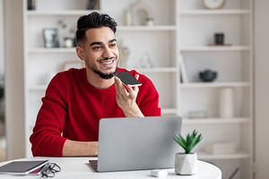 Young Arab Man Using Smartphone For Recording Voice Message At Home, a Photo by Prostock-Studio