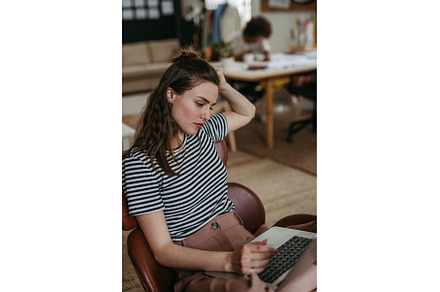 Young woman working on laptop in, a Person Photo by HalfPoint