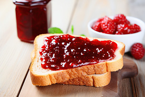 Toasted bread with sweet jam on wooden background, a Food & Drink Photo by AlyaAnd
