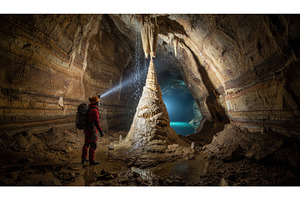 Caver in red suit and helmet stands, a Person Photo by Igor Tichonow