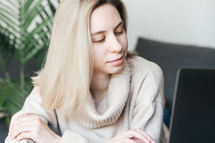 Young woman working on laptop in  home, a Person Photo by Olena Rudo